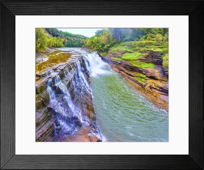 Framed Print : Aerial along stunning waterfall pouring over cliffs with lush forests in background Framed Print : Aerial along stunning waterfall pouring over cliffs with lush forests in background