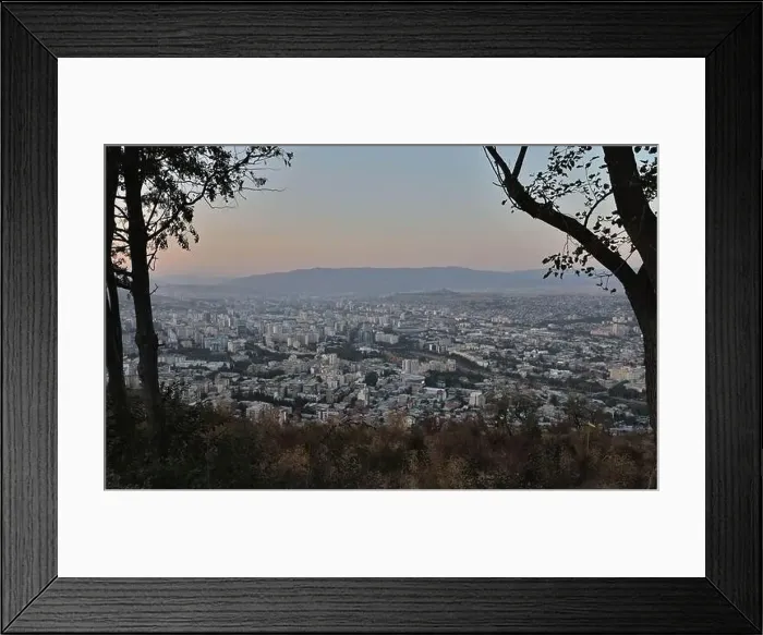 Framed Print : View of Tbilisi City from the mountain, Mtatsminda park, on the sunset throw the trees Framed Print : View of Tbilisi City from the mountain, Mtatsminda park, on the sunset throw the trees