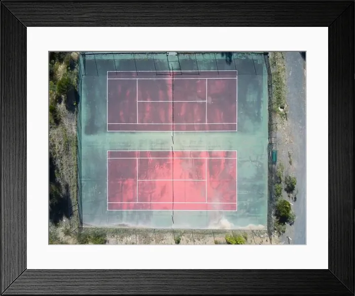 Framed Print : Empty tennis court aerial view showing a red surface court with green edges and white marking lines Framed Print : Empty tennis court aerial view showing a red surface court with green edges and white marking lines