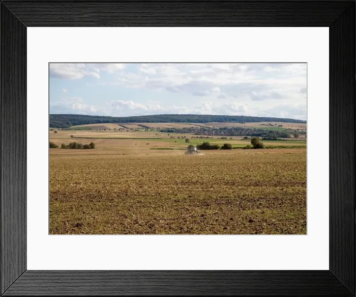 Framed Print : Panorama of a field with a tractor, hilly landscape Framed Print : Panorama of a field with a tractor, hilly landscape