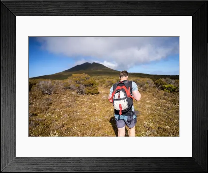Framed Print : man hiking up a mountain with a backpack, alpine wilderness Framed Print : man hiking up a mountain with a backpack, alpine wilderness