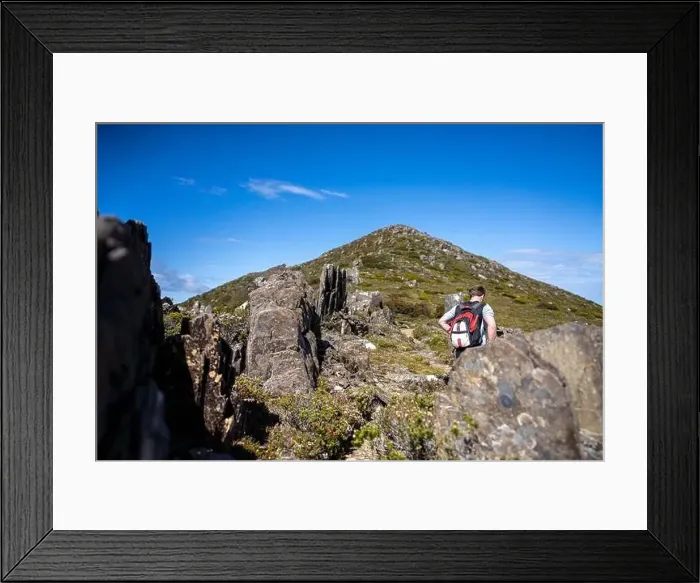 Framed Print : man hiking up a mountain with a backpack, alpine wilderness Framed Print : man hiking up a mountain with a backpack, alpine wilderness