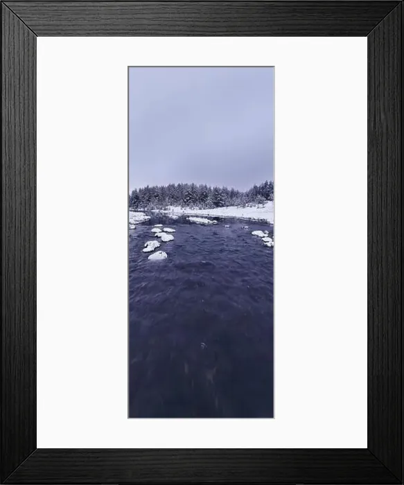 Framed Print : An aerial view of a frozen river flowing through snow-covered forests on a cloudy sunset sky background Framed Print : An aerial view of a frozen river flowing through snow-covered forests on a cloudy sunset sky background