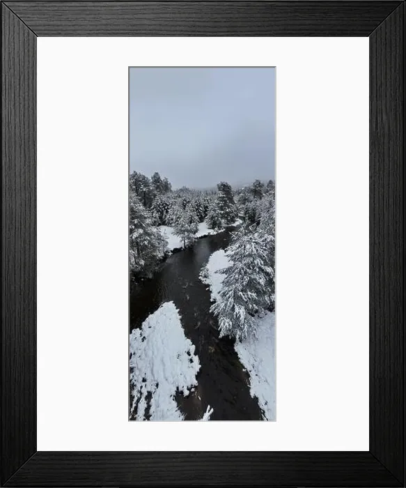 Framed Print : An aerial view of a frozen river flowing through snow-covered forests on a cloudy sunset sky background Framed Print : An aerial view of a frozen river flowing through snow-covered forests on a cloudy sunset sky background