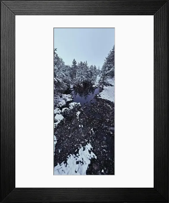 Framed Print : An aerial view of a frozen river flowing through snow-covered forests on a cloudy sunset sky background Framed Print : An aerial view of a frozen river flowing through snow-covered forests on a cloudy sunset sky background