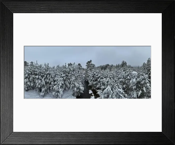 Framed Print : An aerial view of a frozen river flowing through snow-covered forests on a cloudy sunset sky background Framed Print : An aerial view of a frozen river flowing through snow-covered forests on a cloudy sunset sky background