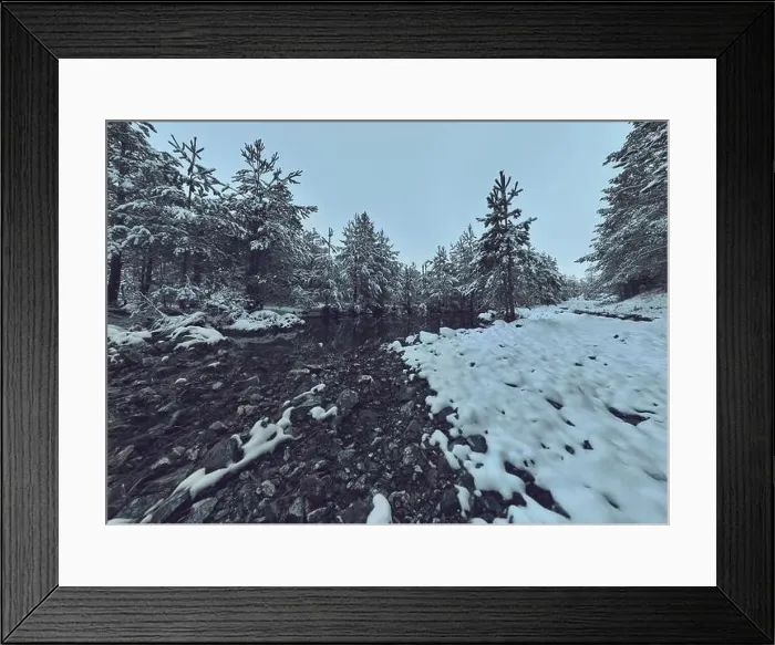 Framed Print : An aerial view of a frozen river flowing through snow-covered forests on a cloudy sunset sky background Framed Print : An aerial view of a frozen river flowing through snow-covered forests on a cloudy sunset sky background