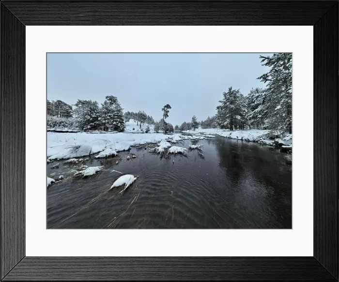 Framed Print : An aerial view of a frozen river flowing through snow-covered forests on a cloudy sunset sky background Framed Print : An aerial view of a frozen river flowing through snow-covered forests on a cloudy sunset sky background