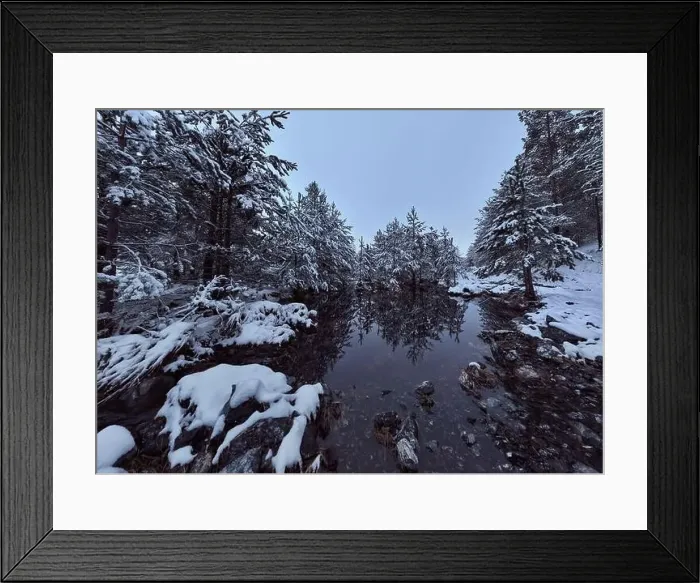 Framed Print : An aerial view of a frozen river flowing through snow-covered forests on a cloudy sunset sky background Framed Print : An aerial view of a frozen river flowing through snow-covered forests on a cloudy sunset sky background