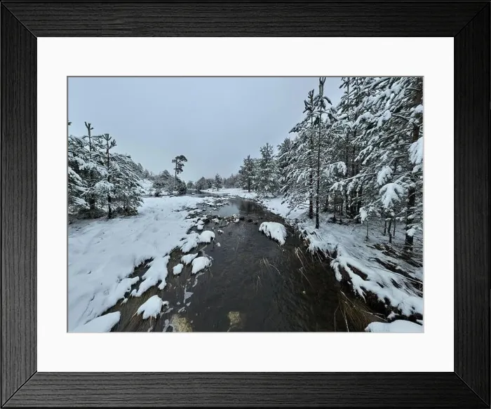 Framed Print : An aerial view of a frozen river flowing through snow-covered forests on a cloudy sunset sky background Framed Print : An aerial view of a frozen river flowing through snow-covered forests on a cloudy sunset sky background