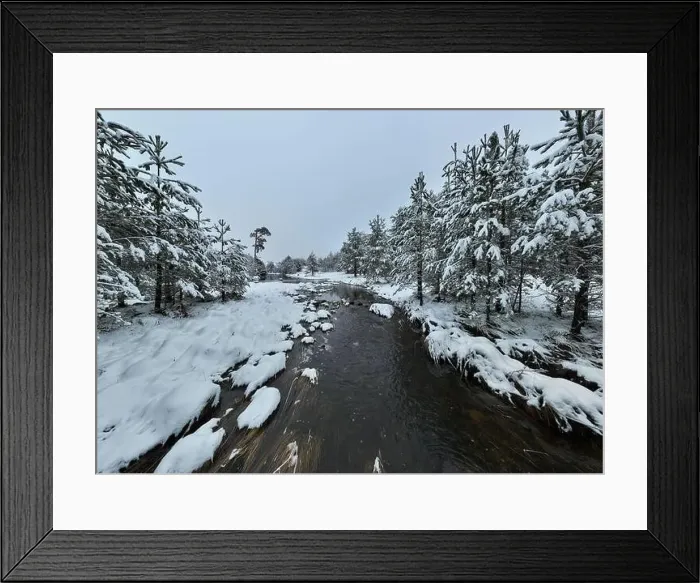Framed Print : An aerial view of a frozen river flowing through snow-covered forests on a cloudy sunset sky background Framed Print : An aerial view of a frozen river flowing through snow-covered forests on a cloudy sunset sky background