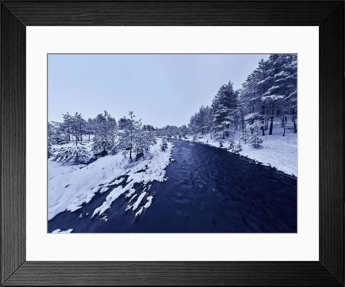 Framed Print : An aerial view of a frozen river flowing through snow-covered forests on a cloudy sunset sky background Framed Print : An aerial view of a frozen river flowing through snow-covered forests on a cloudy sunset sky background