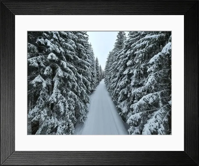 Framed Print : Aerial drone view of the road in idyllic winter landscape nature in a dense forest with fresh snow Framed Print : Aerial drone view of the road in idyllic winter landscape nature in a dense forest with fresh snow