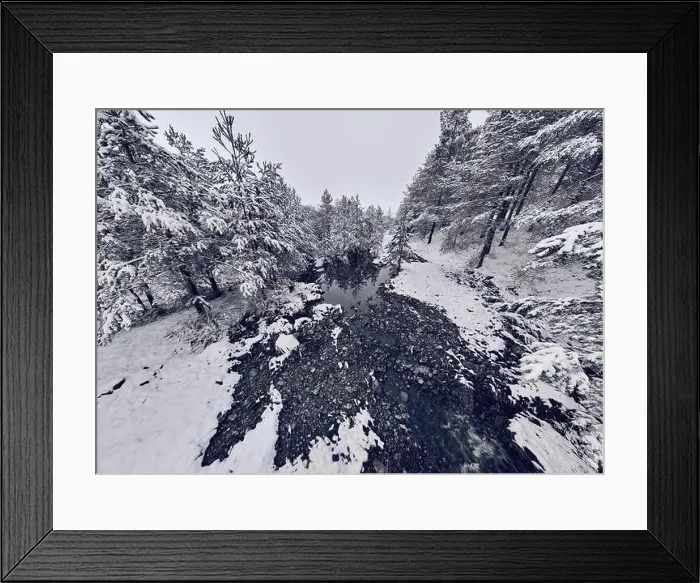 Framed Print : An aerial view of a frozen river flowing through snow-covered forests on a cloudy sunset sky background Framed Print : An aerial view of a frozen river flowing through snow-covered forests on a cloudy sunset sky background