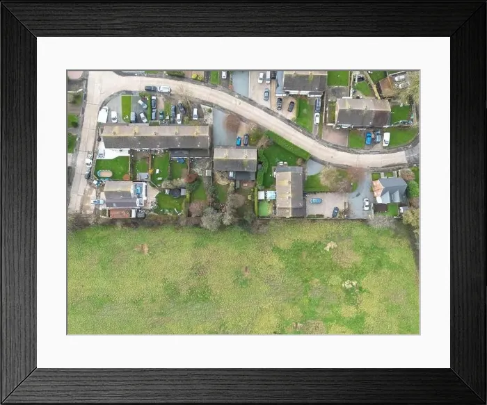 Framed Print : Aerial view of a small rural housing estate in the UK. The adjacent field may soon be developed on for my housing Framed Print : Aerial view of a small rural housing estate in the UK. The adjacent field may soon be developed on for my housing