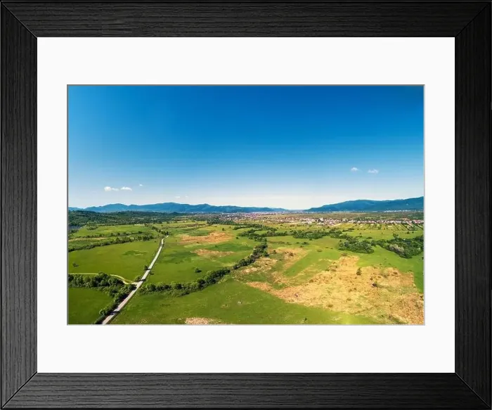 Framed Print : Drone view of the countryside. Road, meadows, and the village in the foothills of the Carpathians Framed Print : Drone view of the countryside. Road, meadows, and the village in the foothills of the Carpathians