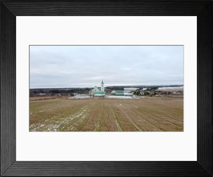 Framed Print : Initial winter. Clip.View from a drone on a landscape with snowy grass in a field where there is a temple with a golden