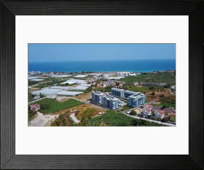 Framed Print : View from a drone flight to the resort area. Clip. View of the sea and the area of hotels and houses with green fields Framed Print : View from a drone flight to the resort area. Clip. View of the sea and the area of hotels and houses with green fields