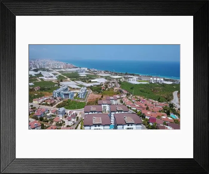 Framed Print : View from a drone flight to the resort area. Clip. View of the sea and the area of hotels and houses with green fields Framed Print : View from a drone flight to the resort area. Clip. View of the sea and the area of hotels and houses with green fields