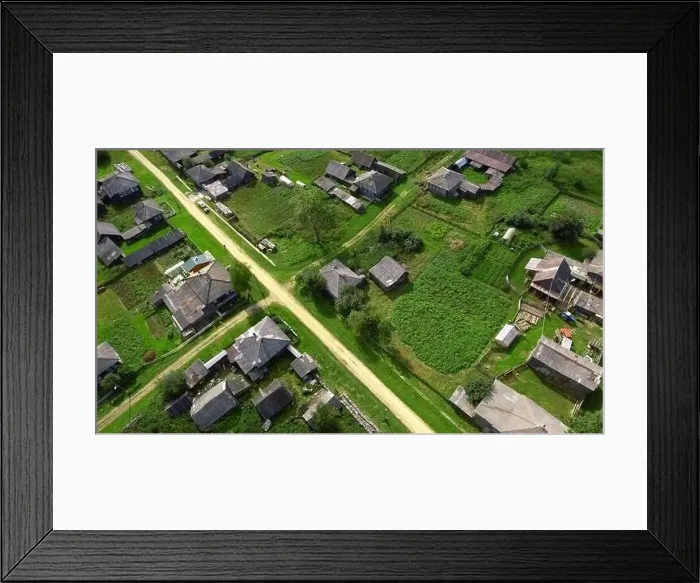 Framed Print : Top view of rustic cottages with green fields Framed Print : Top view of rustic cottages with green fields