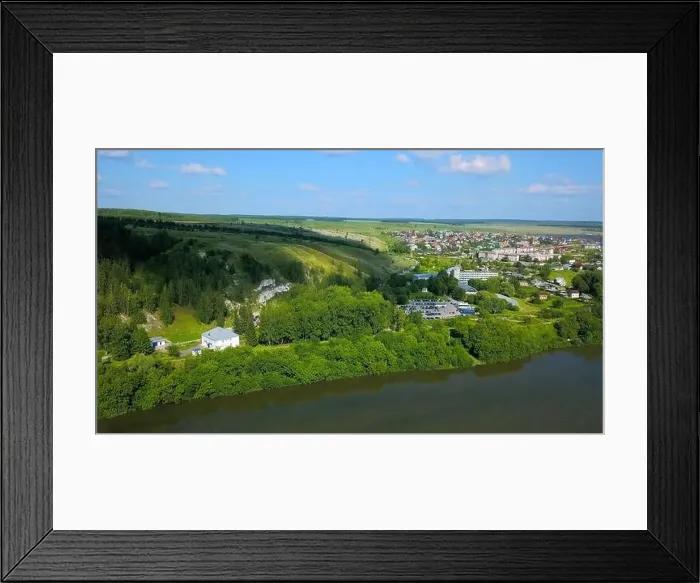 Framed Print : Aerial view of a small green village surrounded by green forest Framed Print : Aerial view of a small green village surrounded by green forest