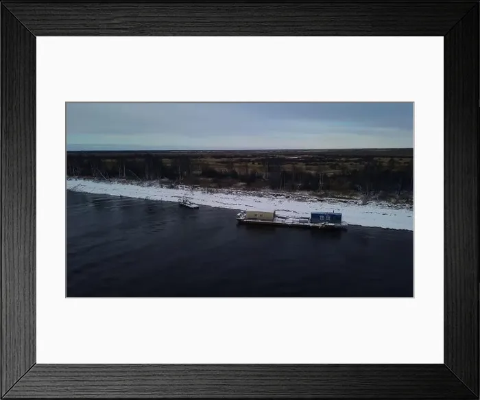 Framed Print : Aerial view of a barge on a winter river with ice. Clip. Concept of water transportation of goods