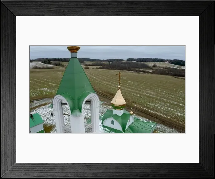 Framed Print : Aerial view of a white and green church with a golden cross and bell. Clip. Green field covered by snow Framed Print : Aerial view of a white and green church with a golden cross and bell. Clip. Green field covered by snow