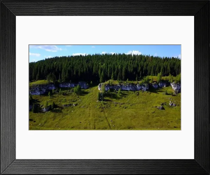 Framed Print : Aerial view of a rock cliff and pine trees. Clip. Flying above green meadows and stone formations Framed Print : Aerial view of a rock cliff and pine trees. Clip. Flying above green meadows and stone formations