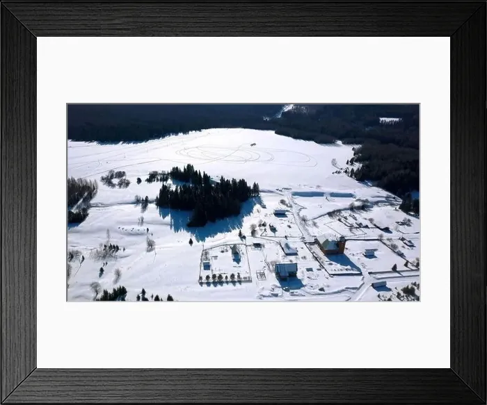 Framed Print : Aerial winter landscape with a snow covered field and growing pine trees Framed Print : Aerial winter landscape with a snow covered field and growing pine trees