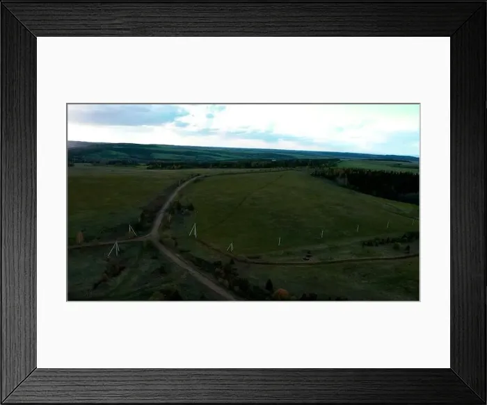 Framed Print : Aerial view of a rural road in the middle of green endless meadows Framed Print : Aerial view of a rural road in the middle of green endless meadows
