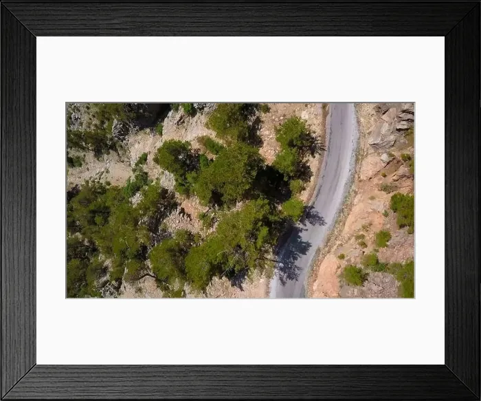 Framed Print : Aerial view of a rural countryside road stretching along bushes. Clip. Curving narrow road and stony ground Framed Print : Aerial view of a rural countryside road stretching along bushes. Clip. Curving narrow road and stony ground