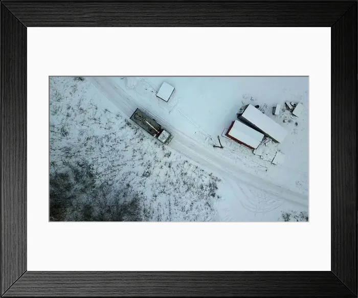 Framed Print : Aerial view of a countryside rural road covered by snow. Clip. Flying above rural road and a village Framed Print : Aerial view of a countryside rural road covered by snow. Clip. Flying above rural road and a village