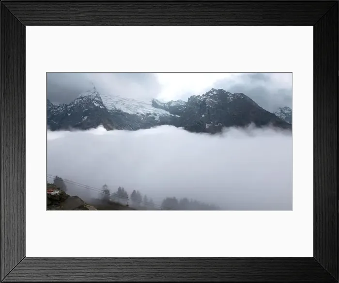 Framed Print : Fly over majestic mountain peaks and a fog. Creative. Valley covered by clouds and mountains on the background Framed Print : Fly over majestic mountain peaks and a fog. Creative. Valley covered by clouds and mountains on the background