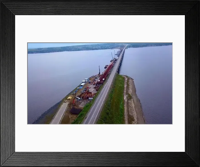 Framed Print : Aerial view of a long bridge crossing a wide river. Clip. Process of bridge construction Framed Print : Aerial view of a long bridge crossing a wide river. Clip. Process of bridge construction