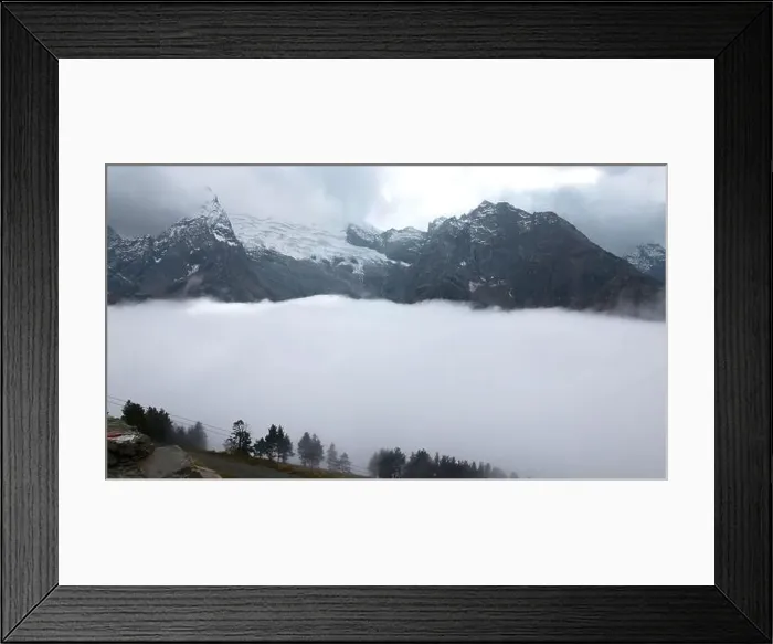 Framed Print : Fly over majestic mountain peaks and a fog. Creative. Valley covered by clouds and mountains on the background Framed Print : Fly over majestic mountain peaks and a fog. Creative. Valley covered by clouds and mountains on the background