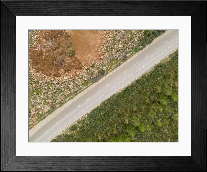 Framed Print : Aerial view of the road with trees on one side and dirt on the other Framed Print : Aerial view of the road with trees on one side and dirt on the other