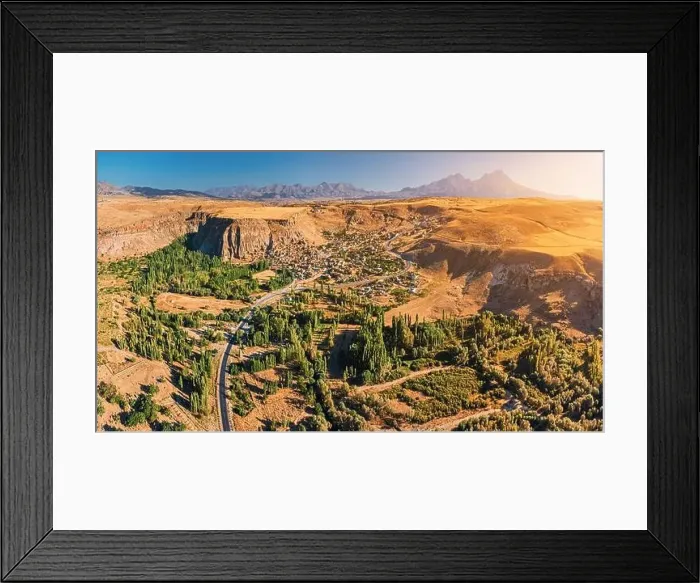 Framed Print : Aerial view of a village on a highland plateau in Cappadocia, with Hasandag volcano mountain in the background Framed Print : Aerial view of a village on a highland plateau in Cappadocia, with Hasandag volcano mountain in the background