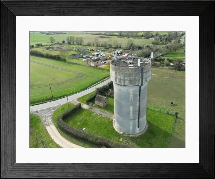 Framed Print : Drone view of a concrete water tower which has an array of 5G antennas on its circular roof Framed Print : Drone view of a concrete water tower which has an array of 5G antennas on its circular roof