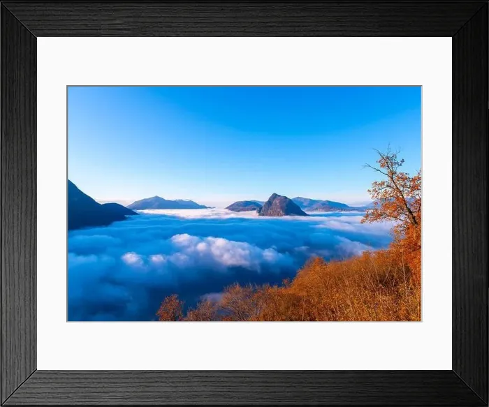 Framed Print : Mountain Peak San Salvatore Above Cloudscape with a Autumn Tree and Sunlight with Clear Sky in Lugano Framed Print : Mountain Peak San Salvatore Above Cloudscape with a Autumn Tree and Sunlight with Clear Sky in Lugano