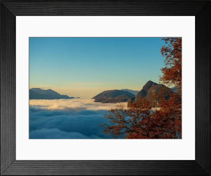 Framed Print : Mountain Peak San Salvatore Above Cloudscape with a Autumn Tree and Sunlight with Clear Sky in Lugano Framed Print : Mountain Peak San Salvatore Above Cloudscape with a Autumn Tree and Sunlight with Clear Sky in Lugano