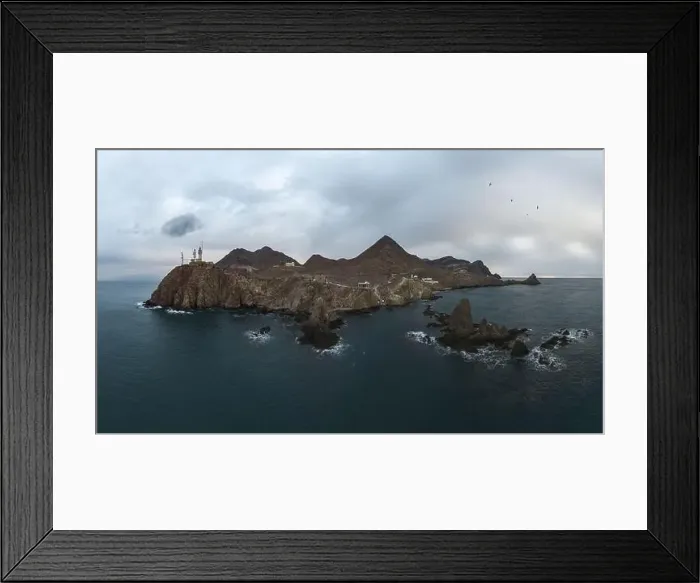 Framed Print : Drone view of lighthouse located on rough cliff near sea under cloudy sky in Almeria