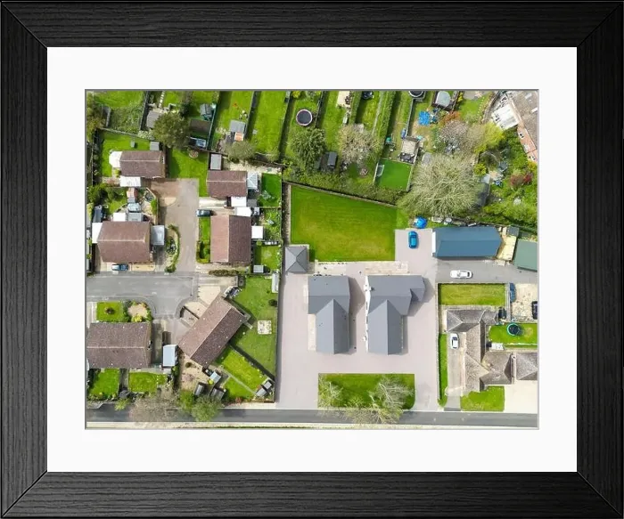 Framed Print : Aerial top down view of a pair of new detached bungalows seen adjacent to established housing and gardens Framed Print : Aerial top down view of a pair of new detached bungalows seen adjacent to established housing and gardens
