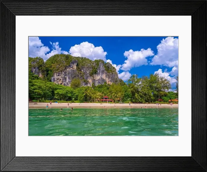 Framed Print : Bungalow house with red roof among coconut palms near the cliffs with people sunbathing Framed Print : Bungalow house with red roof among coconut palms near the cliffs with people sunbathing