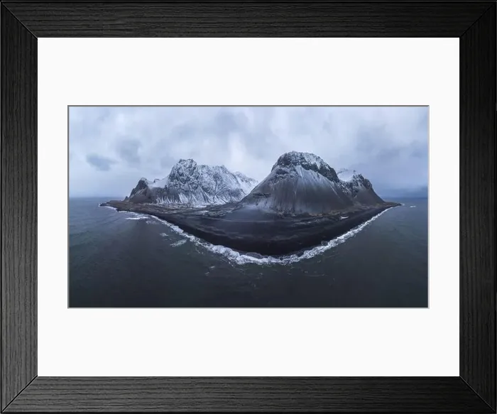 Framed Print : Drone view of sea waves washing stony beach with snowy mountains against cloudy sky in Iceland Framed Print : Drone view of sea waves washing stony beach with snowy mountains against cloudy sky in Iceland