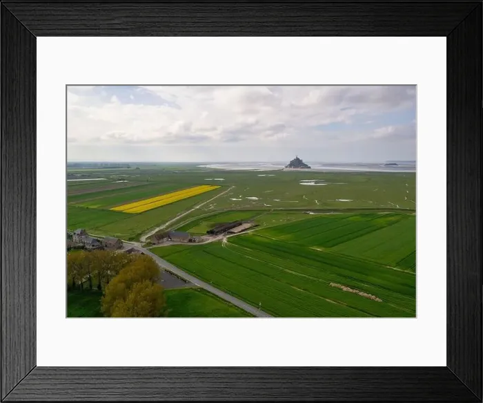 Framed Print : Beautiful drone view of famous Le Mont Saint-Michel tidal island with blue sky and yellow fields of rapeseed Framed Print : Beautiful drone view of famous Le Mont Saint-Michel tidal island with blue sky and yellow fields of rapeseed