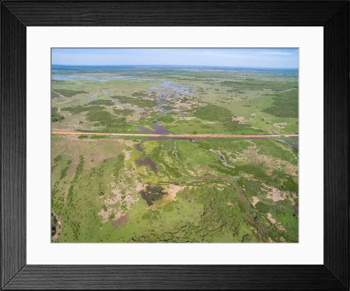 Framed Print : Aerial view of Transpantaneira dirt road crossing a lagoon over a small bridge in the typical landscape of North Framed Print : Aerial view of Transpantaneira dirt road crossing a lagoon over a small bridge in the typical landscape of North