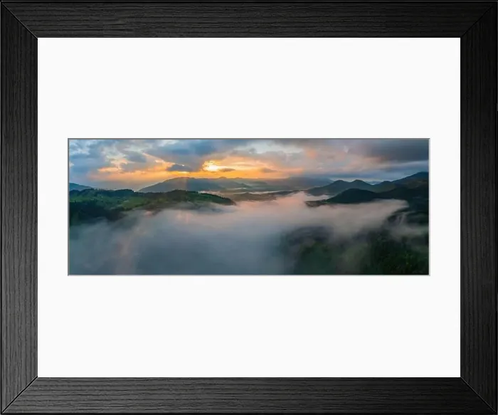 Framed Print : Fog envelops the mountain forest. The rays of the rising sun break through the fog. Aerial drone view Framed Print : Fog envelops the mountain forest. The rays of the rising sun break through the fog. Aerial drone view