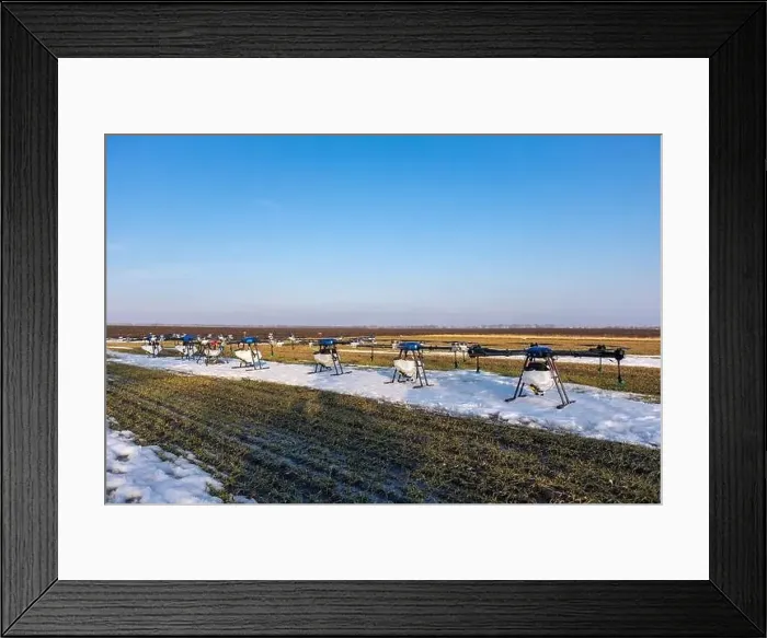 Framed Print : Many agrodrones are on the green field. The snow has not melted yet. Agrodrons are ready to spray fertilizer