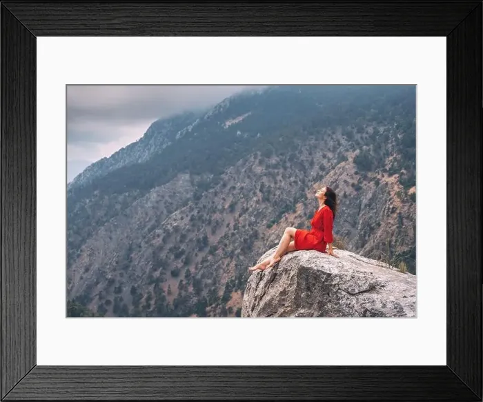 Framed Print : Romantic aerial photo of a girl in a red dress on top of a cliff admiring the view of a mountain gorge
