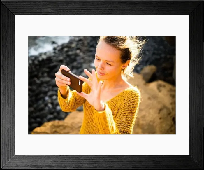 Framed Print : Pretty, young woman taking photos with her smartphone during her vacation Framed Print : Pretty, young woman taking photos with her smartphone during her vacation